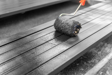 Worker painting steel post in construction site.