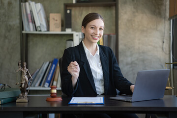 Portrait of a young female Lawyer or attorney working in the office, smiling and looking at the...