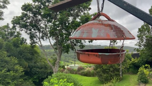 Beautiful tranquil slider shot of an antique old bird table suspended in the foreground in fron of a lush and serene Queenland hinterland valley