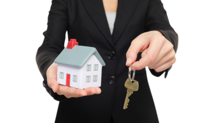 Real estate agent new house keys concept. Realtor showing holding house keys and mini house model. Buying new home conceptual image with business woman in suit isolated in transparent PNG