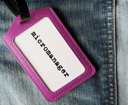 Purple ID card holder with text written MICROMANAGER refer to a boss or manager who gives excessive supervision to employees, control every part of project