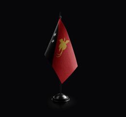 Obraz premium Small national flag of the Papua New Guinea on a black background