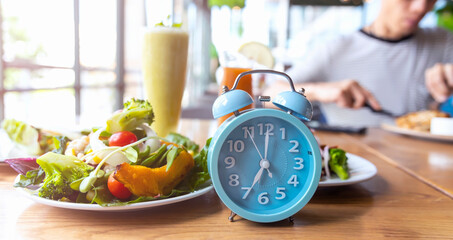 Blue alarm clock with IF (Intermittent Fasting) 16 and 8 diet rule and weight loss concept.-Diet...