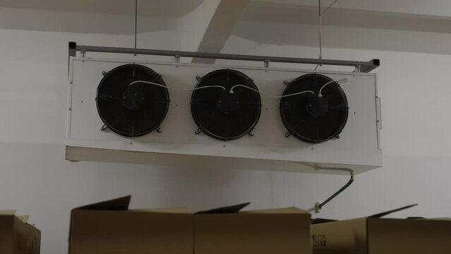 Huge industrial air cooler used inside the production factory storage room. Industrial air cooler keeping the stable temperature in a building. Industrial air cooler blowing out the wind.