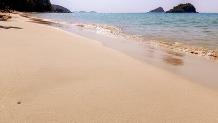 The golden sand reflects the sunlight, the calm nature of the sea.