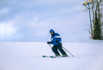 Senior downhill skier skiing in Colorado on cloudy winter day