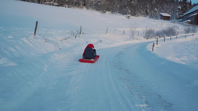 A little boy plays Sledge on Christmas day during winter in Norway