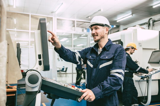 CNC Lathe Machine Engineer Operator Worker Working Entering Work Batch Production Program Data at Heavy Metal Factory - Powered by Adobe