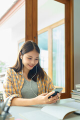 Education and literacy concept, College girl chatting with friend on smartphone after reading book