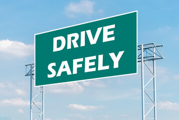 Message DRIVE SAFELY on green road sign with blue sky background