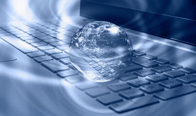 Glass globe on laptop keyboard with many stars 