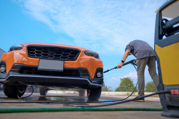 Owner of the car in action of self-services in domestic home, cleaning car self services by owner...