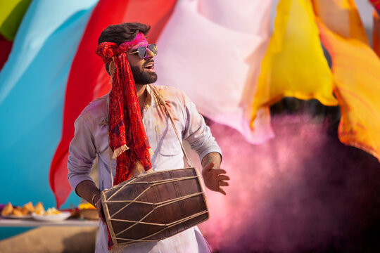 Man playing on a dhol, during holi celebrations