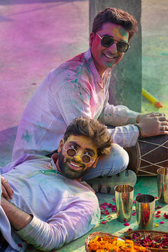 two young men enjoying holi festival together with bhang
