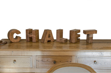 wooden cubes forming the word Chalet, placed on a furniture and used for decoration purposes.Png file..