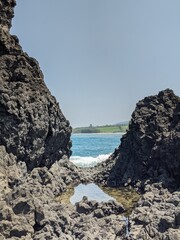 rocks and sea, with the coast in the background