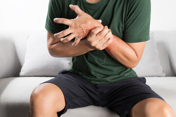 Acute pain in a asian man wrist. - obrazy, fototapety, plakaty