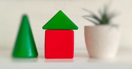 house made of toy plastic blocks of red-green color on a white background