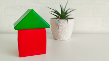 house made of toy plastic blocks of red-green color on a white background