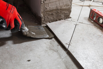 The work of a tiler when finishing - laying porcelain stoneware