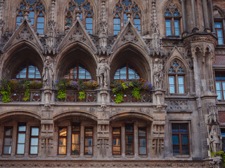 Fototapeta na wymiar Facade of Neo-Gothic town hall with daily performances to the sound of bells and a tall tower overlooking the city in Marienplatz Munich