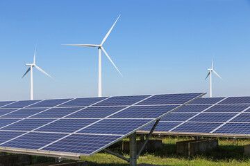 solar cells with wind turbines generating electricity in hybrid power plant systems station on blue sky background  - 570179002