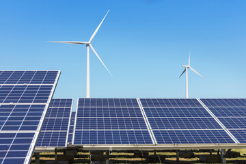 Solar panels and wind turbines generating electricity is solar energy and wind energy in hybrid power plant systems station 