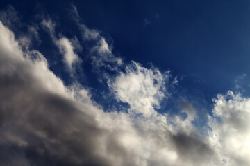Naklejka na ściany i meble Blue sky with sunlight clouds.
