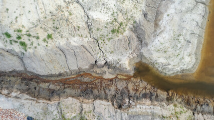 Aerial drone photo of Quarry turquoise green lake colour and the pathways of the equipment and excavators, open pit clay mining in Belgium. High quality photo