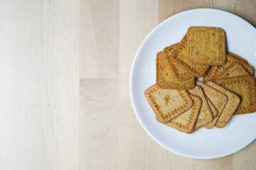 Homemade thin crispy crackers on white plate, Selective Focus.