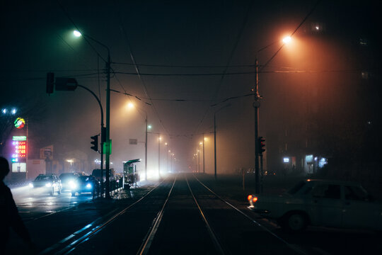 Foggy city street with tram ways during autumn at night - Powered by Adobe
