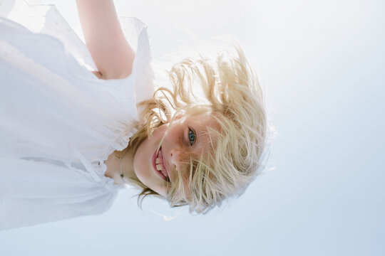 Child with blond hair looking at the camera from above