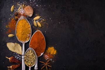 Different spices and herbs on a black background