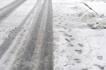 雪の日の市街地の道路、タイヤの痕 (Tire tracks on the city street on a snowy day)
