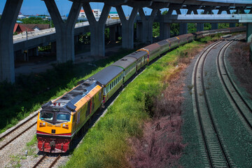 Passenger train by diesel locomotive passes the railway curve. 