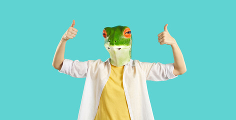 Creative recommendation. Funny humorous woman in rubber mask of frog's head shows thumbs up on...