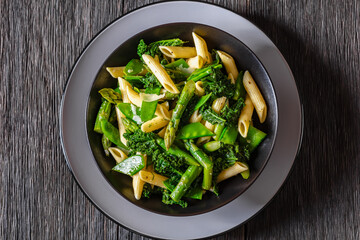 Pasta primavera with green veggies, cheese in bowl