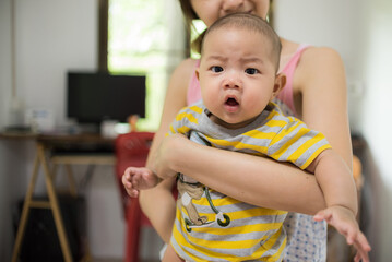 Asia mother playing with baby boy in home