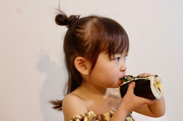 節分に恵方巻きを食べる女の子