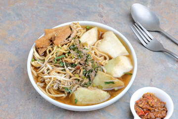 Mie Kopyok, a traditional noodle from Semarang, Central Java, Indonesia. Noodle mixed with lontong (rice cake), tofu, bean sprouts, leeks and crackers. Served with sambal (chilli sauce).
