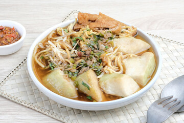 Mie Kopyok, a traditional noodle from Semarang, Central Java, Indonesia. Noodle mixed with lontong (rice cake), tofu, bean sprouts, leeks and crackers. Served with sambal (chilli sauce).

