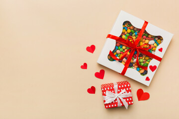 Valentine day composition: sweet candy, with gift boxes with bow and red felt hearts, photo template, background. Top View with copy space