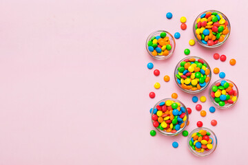 different colored round candy in bowl and jars. Top view of large variety sweets and candies with copy space