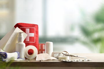 Emergency home kit on wooden table and warm room background