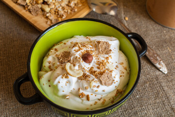 Granola and yogurt for breakfast. Healthy food concept. Plate with yogurt and granola on jute tablecloth