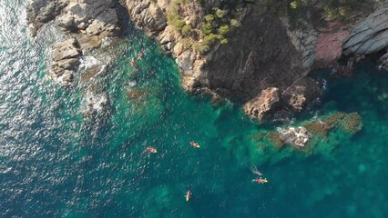 4k birds eye view of a group of kayakers off the coast of Spain.