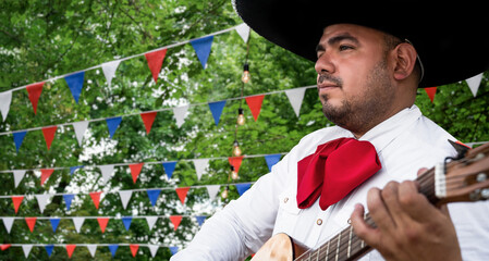 Mexican musician mariachi with guitar on a blurred party background	