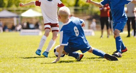 Soccer football tackle moment. Skill of tackling in soccer game.  Kids kicking soccer ball on grass...
