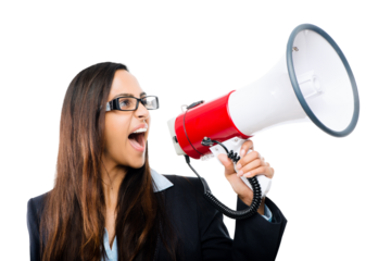 An excited young businesswoman or an entrepreneur in a business suit shouting out joy into a megaphone isolated on a png background.