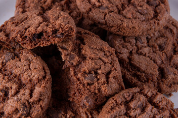 Tasty chocolate chip cookies on white plate on wooden background. Selective focus.